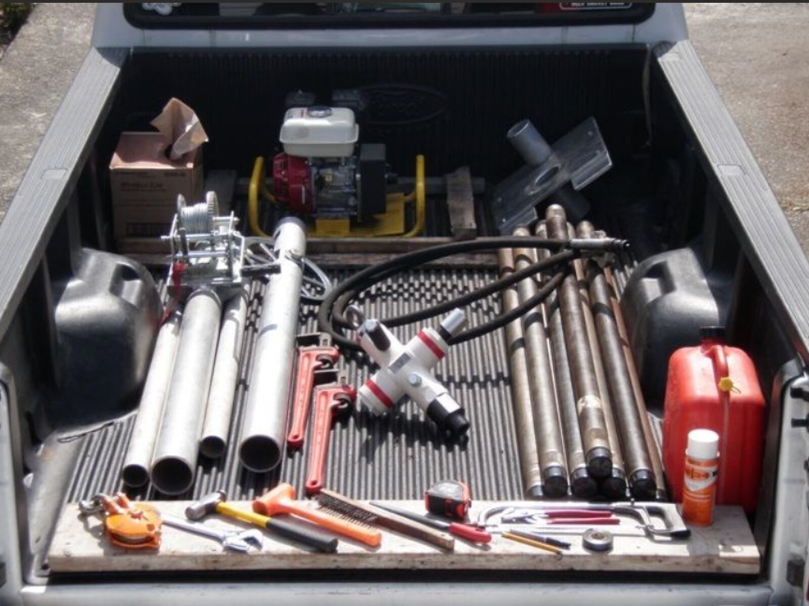 Full VibraCore drill package packed in a truck bed: power plant, gin pole, flex cable, and drill rods